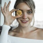 Garota sorrindo com bitcoin na mão